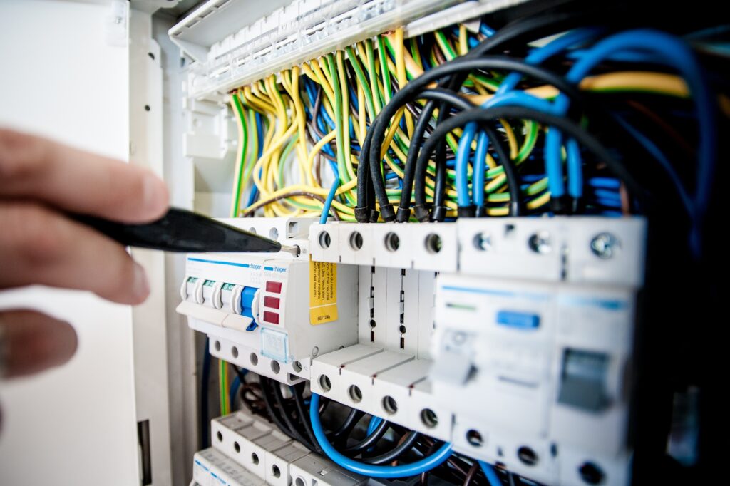 hand holding tool at an electrical board