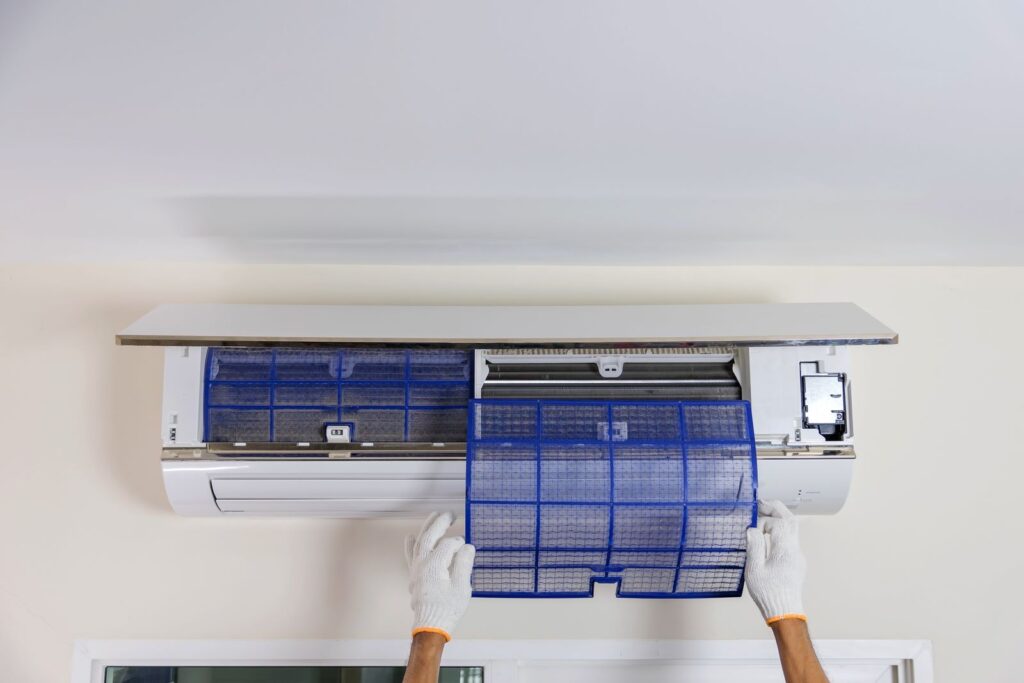 technician removing air filter in air conditioner