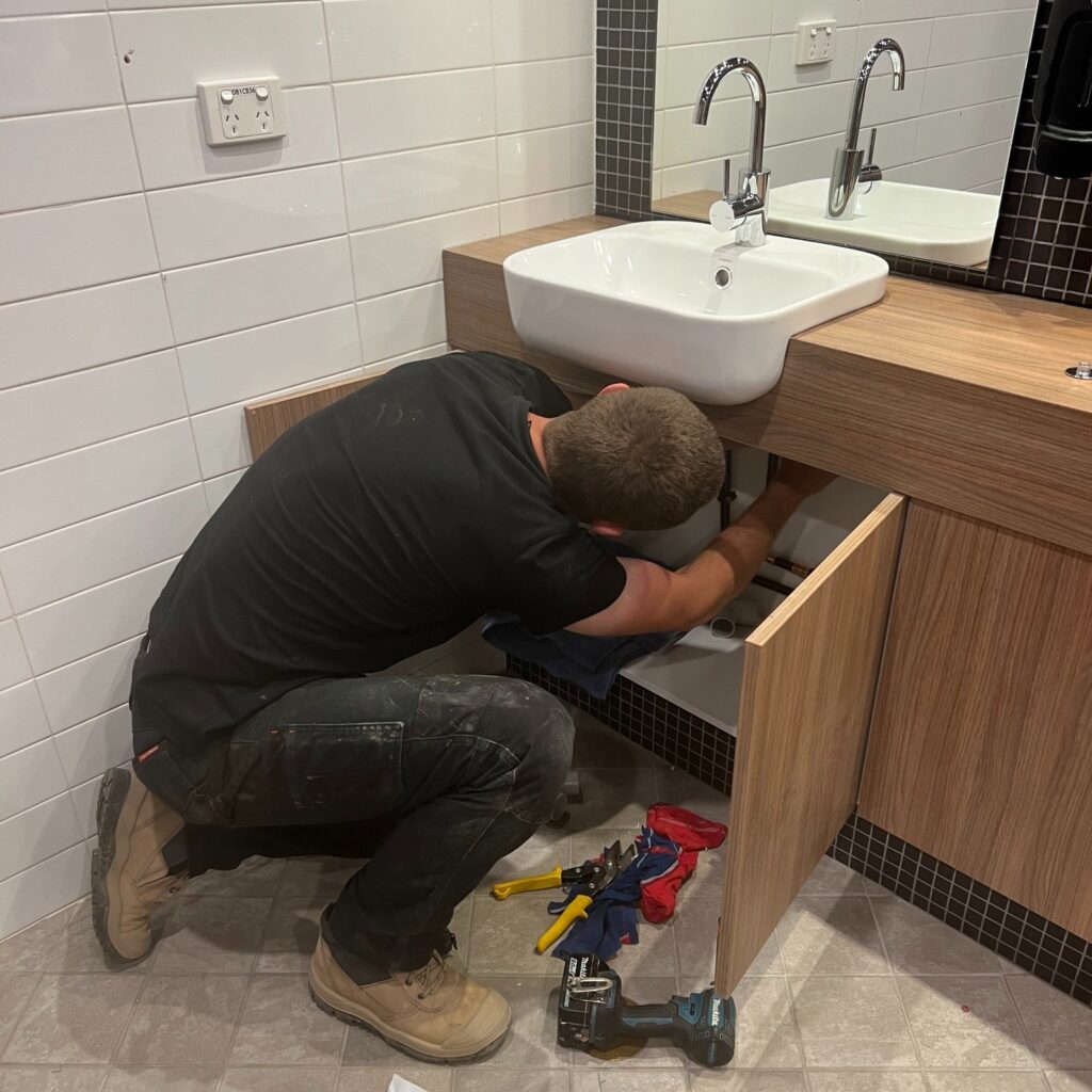 plumber fixing bathroom sink