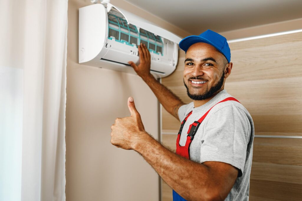 man smiling while fixing air conditioner unit